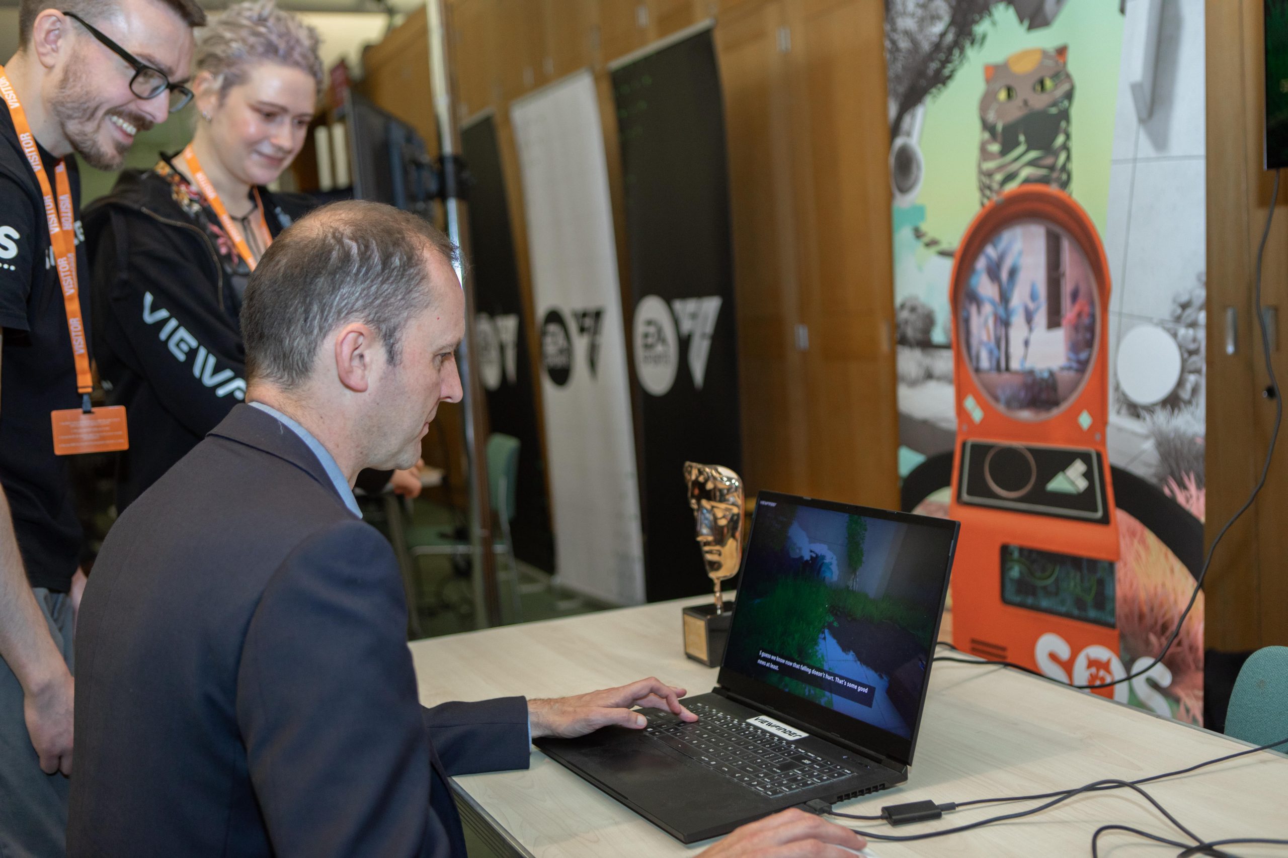 Professional man sitting at a laptop playing video games at a video games event at Westminster