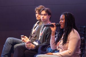 Woman asking a question on a microphone at Ukie members day