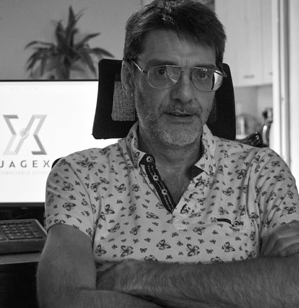 Black and white image of a man wearing glasses and a patterned polo shirt called Kelvin Plomer