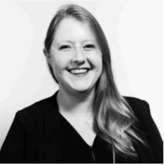 Black and white portrait image of a woman with long hair smiling at the camera. Her name is Melissa Phillips